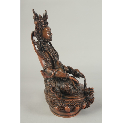 84 - A TIBETAN BRONZE SEATED DEITY, on a lotus base, 29.5cm high.