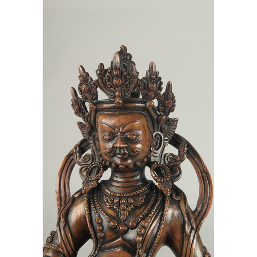 84 - A TIBETAN BRONZE SEATED DEITY, on a lotus base, 29.5cm high.