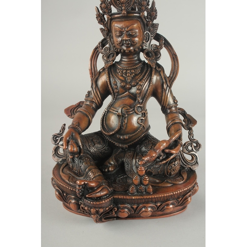 84 - A TIBETAN BRONZE SEATED DEITY, on a lotus base, 29.5cm high.