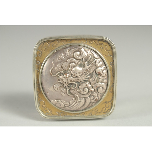 97 - A SMALL SIGNED JAPANESE WHITE METAL AND BRASS BOX, the hinged lid with relief dragon roundel, 5cm sq... 