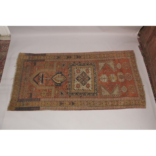 1002 - A PERSIAN RUG, rust ground with geometric stylised decoration. 7ft 7ins x 3ft 11ins.