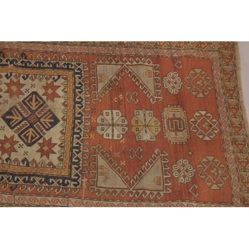 1002 - A PERSIAN RUG, rust ground with geometric stylised decoration. 7ft 7ins x 3ft 11ins.