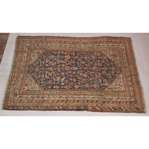 1003 - A PERSIAN RUG dark blue ground with stylised decoration. 7ft x 4ft 7ins.