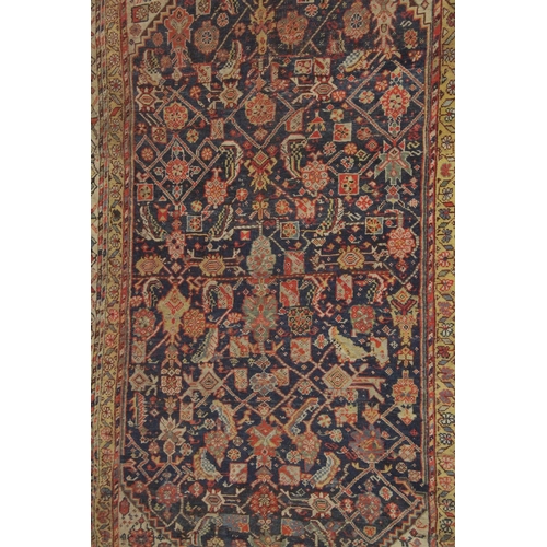 1003 - A PERSIAN RUG dark blue ground with stylised decoration. 7ft x 4ft 7ins.