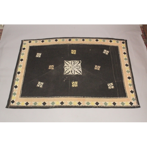 1006 - A QUILTED BEDSPREAD black ground with geometric designs. 7ft 4ins x 4ft 4ins.