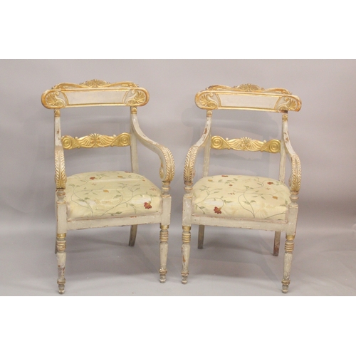 1023 - A GOOD PAIR OF REGENCY CREAM PAINTED AND GILDED ARM CHAIRS with accanthus curving drop in padded sea... 