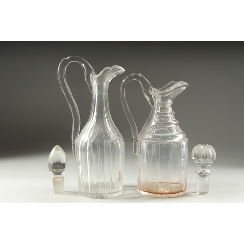 1048 - TWO HEAVY CUT GLASS CLARET JUGS AND STOPPERS.