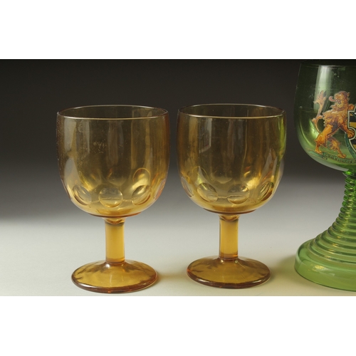 1049 - A LARGE ARMORIAL GREEN GOBLET, 8ins high and four plain amber goblets (5).