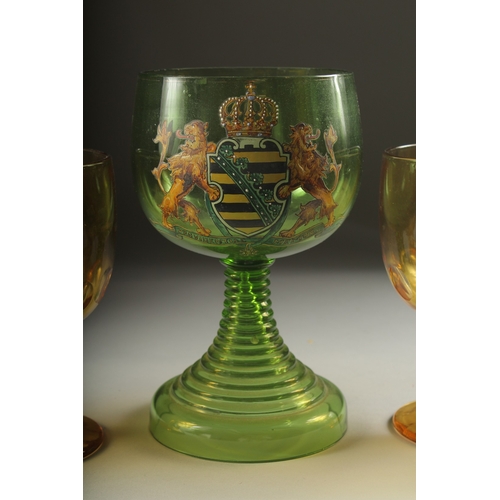 1049 - A LARGE ARMORIAL GREEN GOBLET, 8ins high and four plain amber goblets (5).