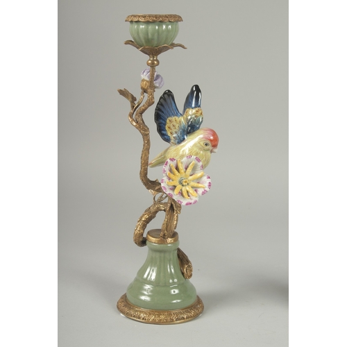 1053 - A GOOD PAIR OF PORCELAIN AND GILDED METAL BIRD CANDLESTICKS on circular bases. 13ins high.