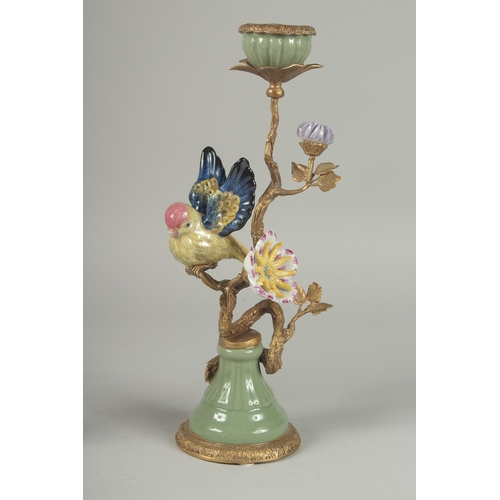 1053 - A GOOD PAIR OF PORCELAIN AND GILDED METAL BIRD CANDLESTICKS on circular bases. 13ins high.