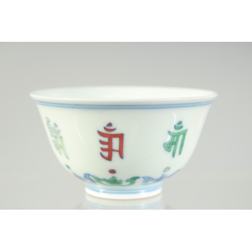 1076 - A CHINESE DOUCAI PORCELAIN CUP, with characters and six-character mark to base, 8.5cm diameter.