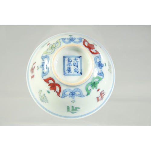 1076 - A CHINESE DOUCAI PORCELAIN CUP, with characters and six-character mark to base, 8.5cm diameter.