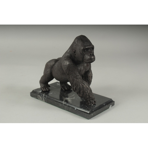 1103 - A BRONZE GORILLA on a marble base. 7ins high.