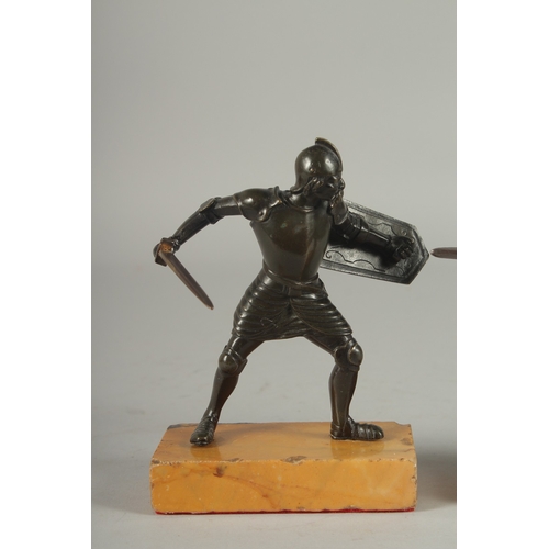 1115 - A GOOD PAIR OF 19TH CENTURY BRONZE FIGHTING SOLDIERS carrying a sword an shield, standing on a yello... 