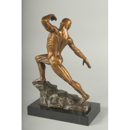 1120 - A SUPERB BRONZE ANATOMICAL MAN STANDING ON A ROCK, on a black marble base. 11ins high.