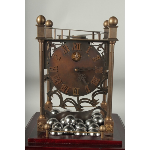 1124 - A ROLLING BALL CLOCK with 21 large chrome balls, in a glass case.