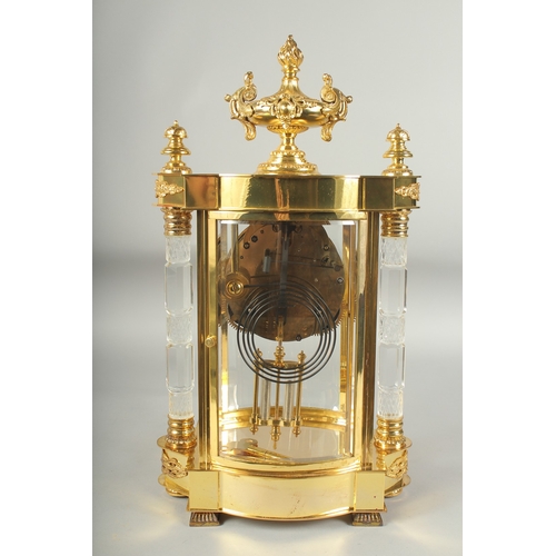 1125 - A GOOD LOUIS XVIthSTYLE GILT METAL SERPENTINE SHAPED FOUR GLASS CLOCK with cut glass columns and urn... 