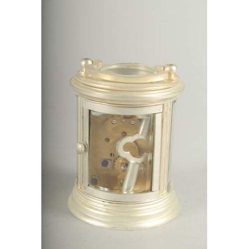 1131 - A SMALL ROUND SILVER CARRIAGE CLOCK. 7cm high.