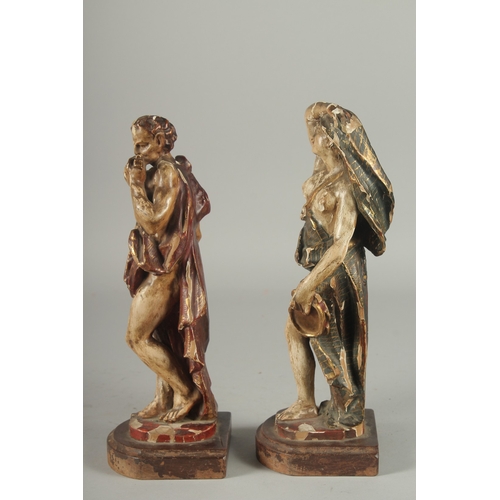 1165 - A GOOD PAIR OF 17TH - 18TH CENTURY CARVED AND POLYCHROMED WOOD FIGURES. A man playing a pan pipe and... 