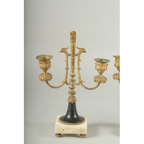 1232 - A GOOD PAIR OF ORMOLU TWO LIGHT CANDLESTICKS on square marble bases.  11ins high.