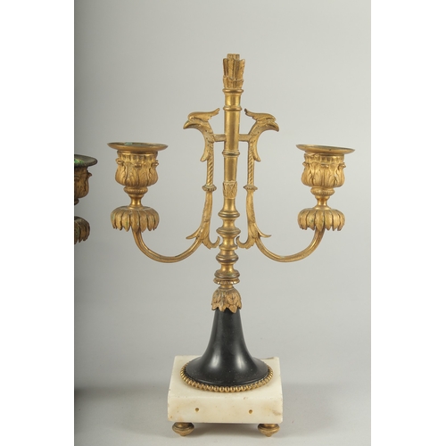 1232 - A GOOD PAIR OF ORMOLU TWO LIGHT CANDLESTICKS on square marble bases.  11ins high.