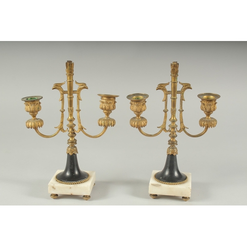 1232 - A GOOD PAIR OF ORMOLU TWO LIGHT CANDLESTICKS on square marble bases.  11ins high.