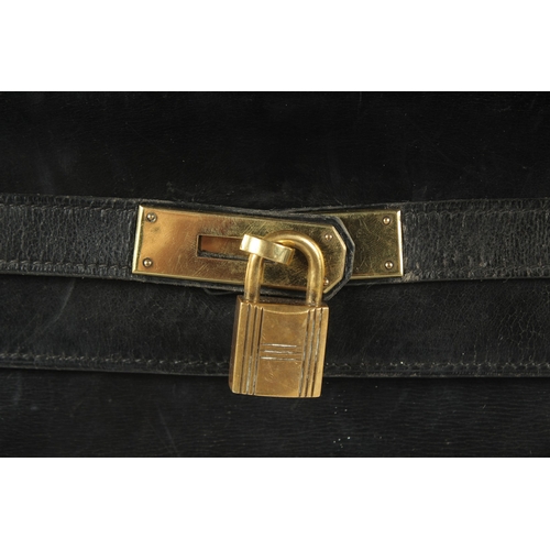 1241 - A GENUINE HERMES BLACK LEATHER KELLY BAG. 11.5ins long, 9ins high with leather handles and brass loc... 