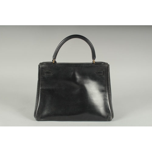 1241 - A GENUINE HERMES BLACK LEATHER KELLY BAG. 11.5ins long, 9ins high with leather handles and brass loc... 