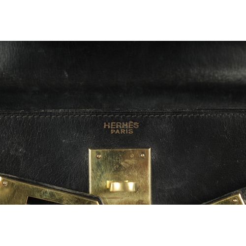 1241 - A GENUINE HERMES BLACK LEATHER KELLY BAG. 11.5ins long, 9ins high with leather handles and brass loc... 