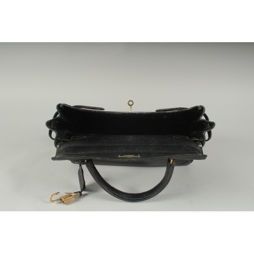 1241 - A GENUINE HERMES BLACK LEATHER KELLY BAG. 11.5ins long, 9ins high with leather handles and brass loc... 