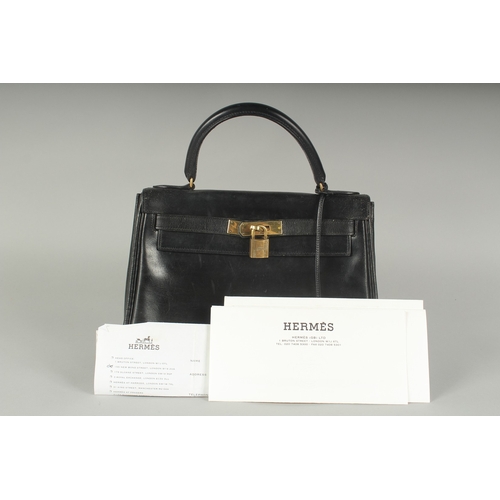 1241 - A GENUINE HERMES BLACK LEATHER KELLY BAG. 11.5ins long, 9ins high with leather handles and brass loc... 