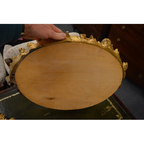 258 - A pair of decorative gilt framed oval wall mirrors.