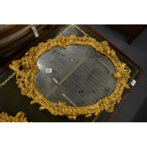 258 - A pair of decorative gilt framed oval wall mirrors.