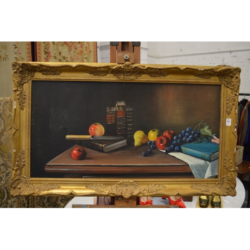 448 - Still life of fruit and books on a table, oil on board in a decorative gilt frame.