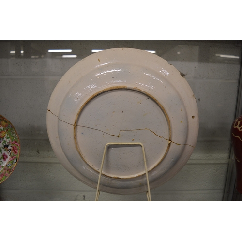 570 - An early polychrome decorated tin glazed circular dish (faults).