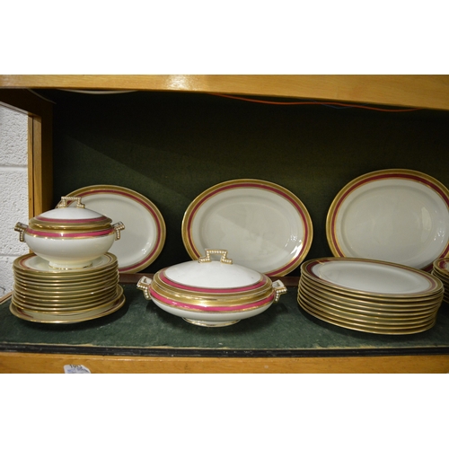 629 - Maple & Co, London, a comprehensive dinner service with gilt and red borders.