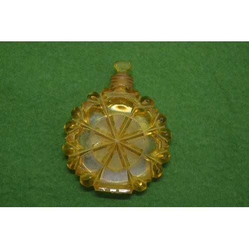 830 - A cut glass amber coloured circular scent bottle and stopper.