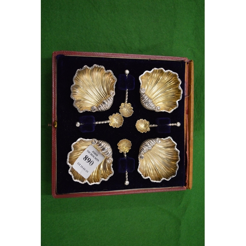 890 - A set of four shell shaped salts with matching spoons.