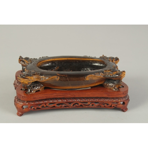106 - A FINE AND UNUSUAL CHINESE CARVED TIGER'S EYE BRUSH WASHER, on a fitted carved hardwood stand, of ov... 