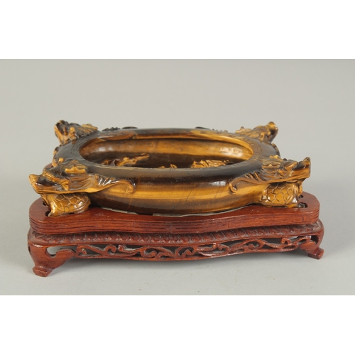 106 - A FINE AND UNUSUAL CHINESE CARVED TIGER'S EYE BRUSH WASHER, on a fitted carved hardwood stand, of ov... 