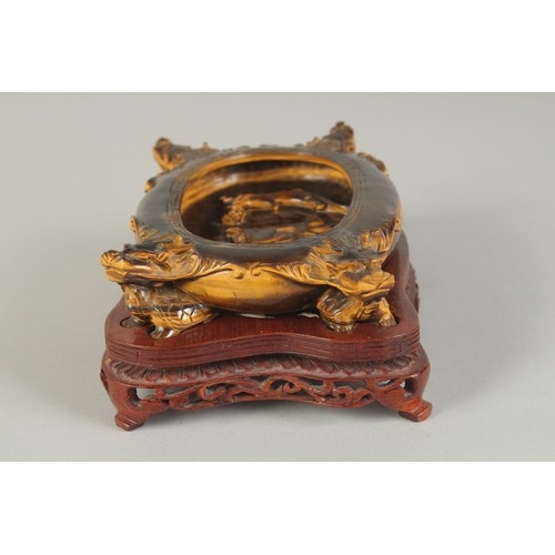 106 - A FINE AND UNUSUAL CHINESE CARVED TIGER'S EYE BRUSH WASHER, on a fitted carved hardwood stand, of ov... 