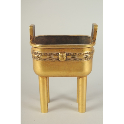 114 - A CHINESE HEAVY GILDED BRONZE TWIN HANDLE CENSER, raised on four tall legs, the base with character ... 