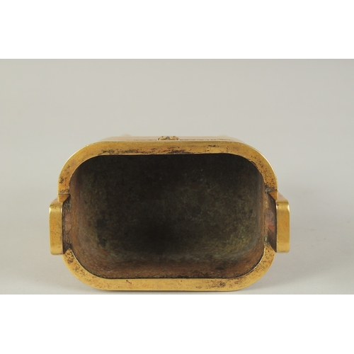 114 - A CHINESE HEAVY GILDED BRONZE TWIN HANDLE CENSER, raised on four tall legs, the base with character ... 