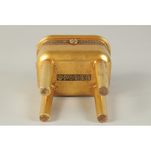 114 - A CHINESE HEAVY GILDED BRONZE TWIN HANDLE CENSER, raised on four tall legs, the base with character ... 