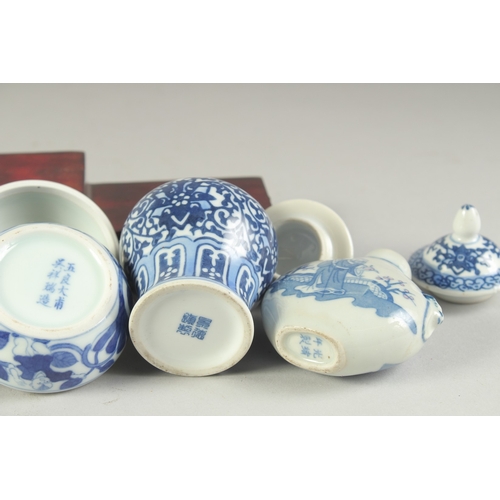 115 - THREE CHINESE BLUE AND WHITE PORCELAIN SNUFF BOTTLES on a tiered wooden stand, together with a pair ... 