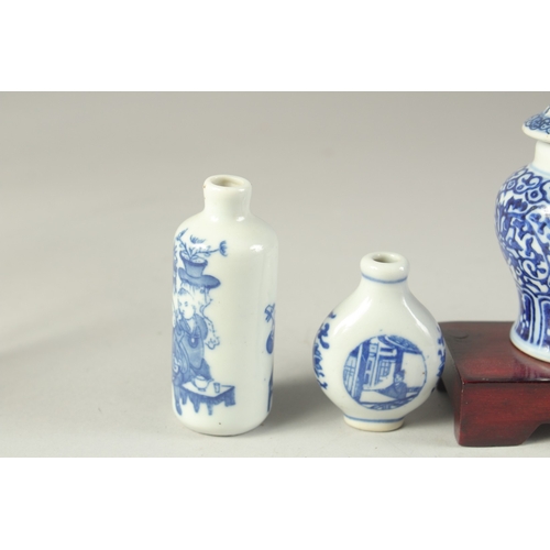 115 - THREE CHINESE BLUE AND WHITE PORCELAIN SNUFF BOTTLES on a tiered wooden stand, together with a pair ... 