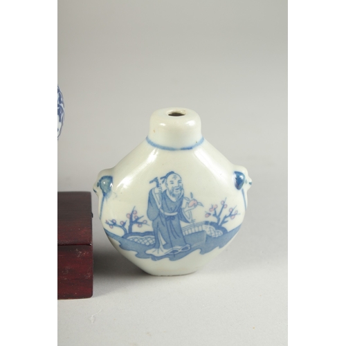 115 - THREE CHINESE BLUE AND WHITE PORCELAIN SNUFF BOTTLES on a tiered wooden stand, together with a pair ... 