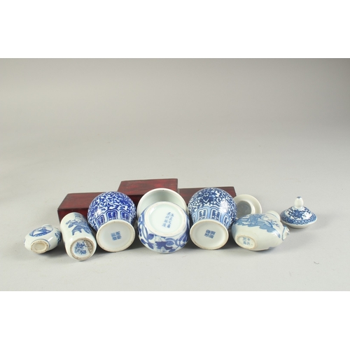 115 - THREE CHINESE BLUE AND WHITE PORCELAIN SNUFF BOTTLES on a tiered wooden stand, together with a pair ... 