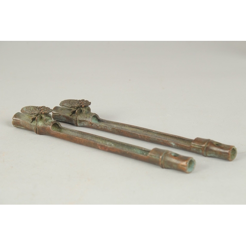 84 - A PAIR OF JAPANESE BRONZE PAPERWEIGHTS, with an insect on bamboo, the underside with mark, 19cm long... 